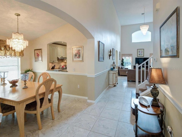 dining area with a notable chandelier and lofted ceiling