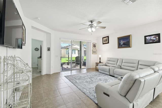 tiled living room with a textured ceiling and ceiling fan