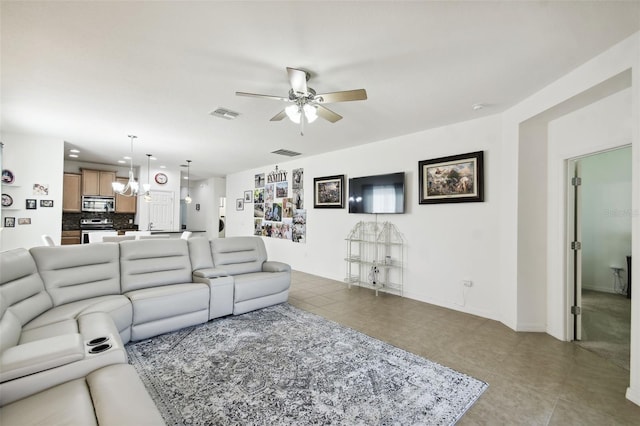 living room with ceiling fan with notable chandelier