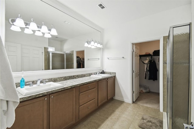 bathroom featuring vanity, tile patterned floors, and a shower with shower door