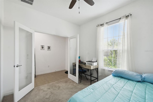 carpeted bedroom with multiple windows, ceiling fan, and french doors