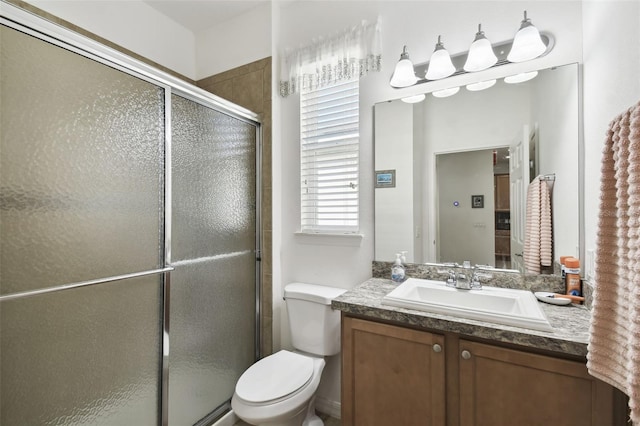 bathroom featuring vanity, toilet, and an enclosed shower