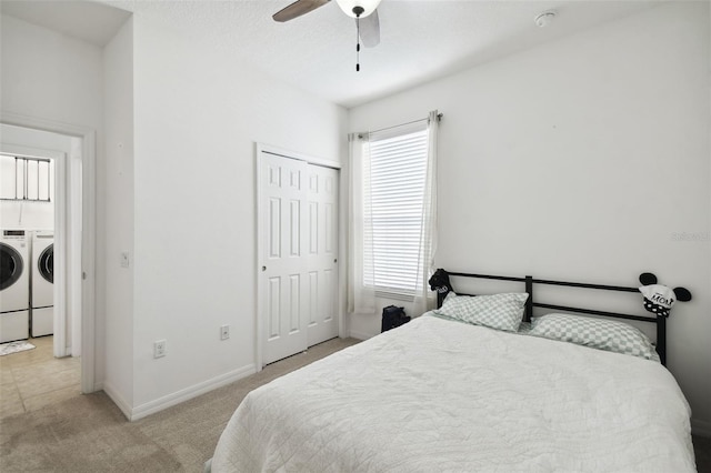 bedroom featuring light carpet, a closet, ceiling fan, and separate washer and dryer