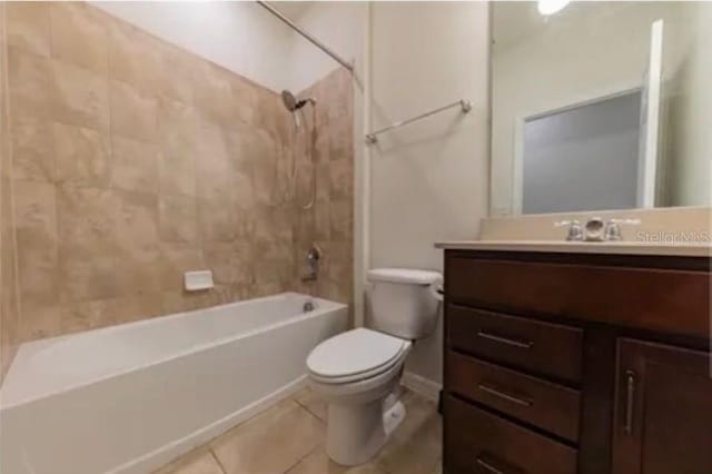 full bathroom with tiled shower / bath, vanity, toilet, and tile patterned floors