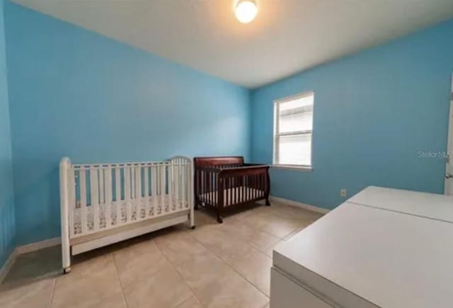 tiled bedroom with a nursery area