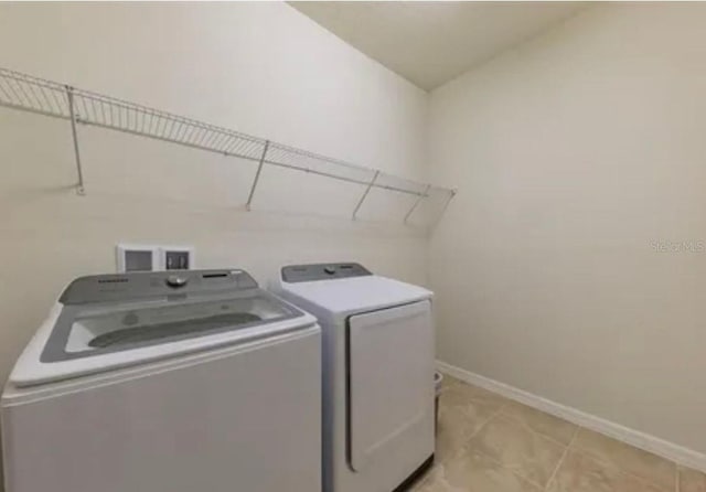 washroom with light tile patterned floors and washer and clothes dryer