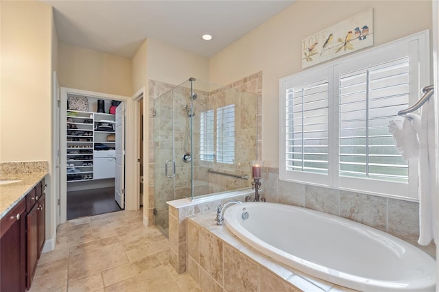 341 Navarra Ln, Davenport, FL 33837 - full bathroom with a shower stall, vanity, a spacious closet, and a garden tub
