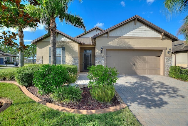 341 Navarra Ln, Davenport, FL 33837 - ranch-style house featuring an attached garage, stone siding, decorative driveway, and stucco siding