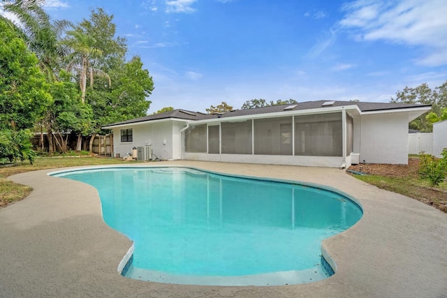 view of swimming pool featuring a sunroom and central AC unit