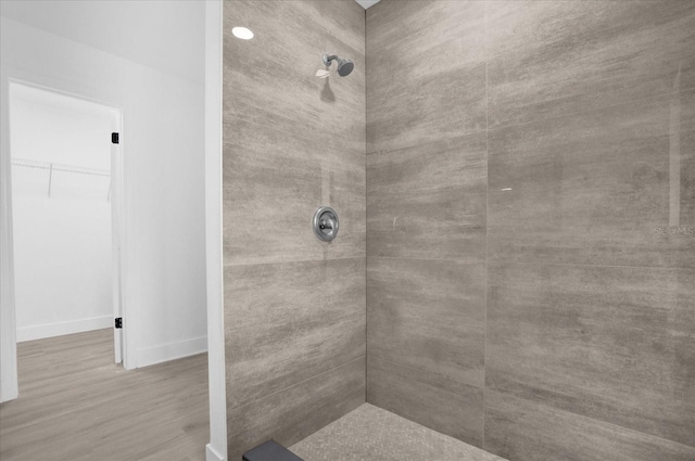 bathroom featuring wood-type flooring and tiled shower