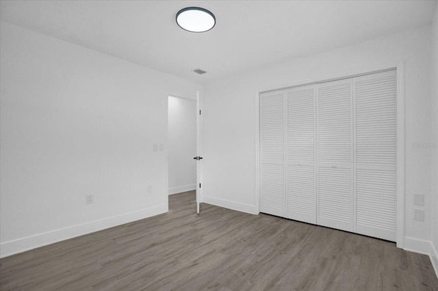 unfurnished bedroom with light wood-type flooring and a closet