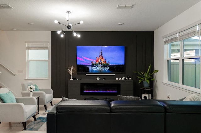 tiled living room featuring a textured ceiling and a chandelier