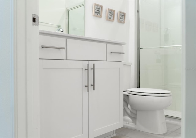 bathroom with vanity, toilet, tile patterned floors, and a shower with door