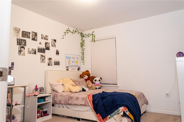 bedroom featuring a textured ceiling and light colored carpet