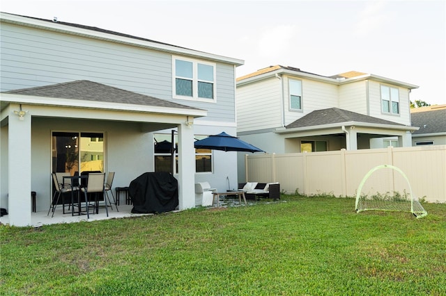 back of property with a patio and a lawn