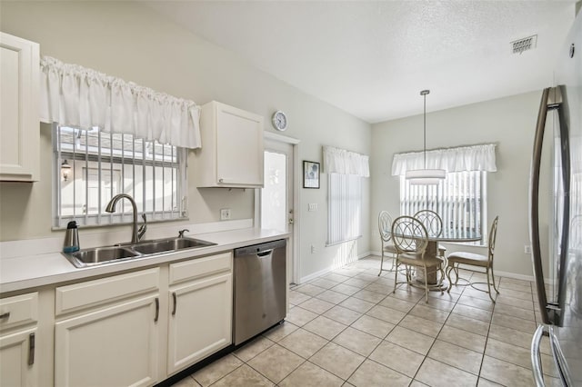 kitchen featuring stainless steel dishwasher, sink, white cabinetry, and plenty of natural light