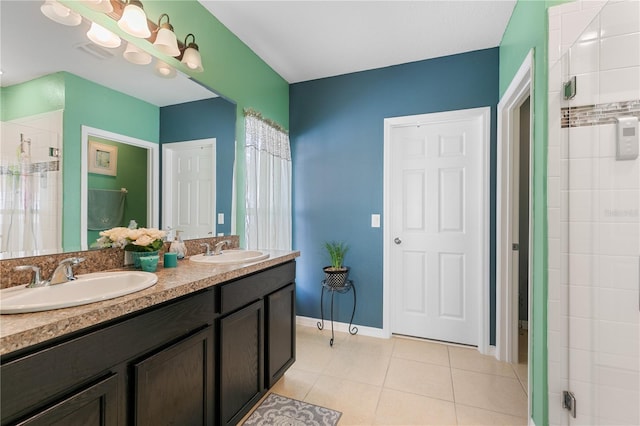 bathroom with tiled shower, vanity, and tile patterned floors