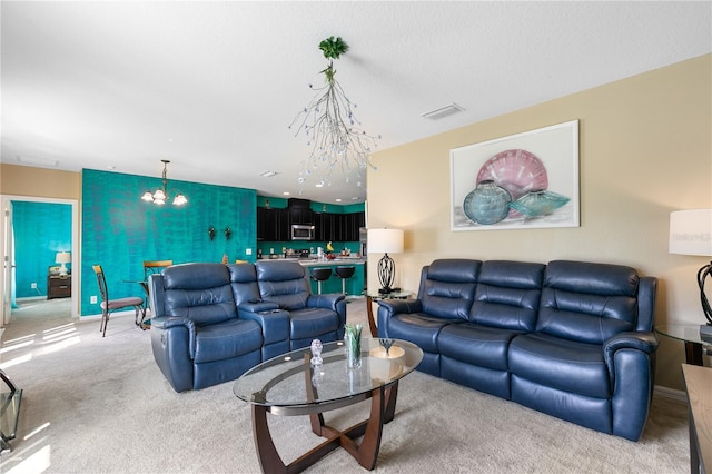 carpeted living room featuring an inviting chandelier