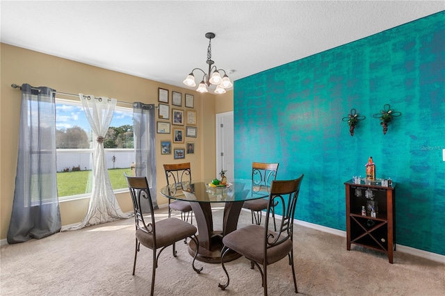 dining room featuring an inviting chandelier, carpet flooring, and a textured ceiling