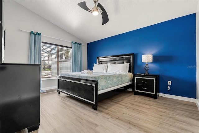 bedroom with ceiling fan, vaulted ceiling, and light hardwood / wood-style floors