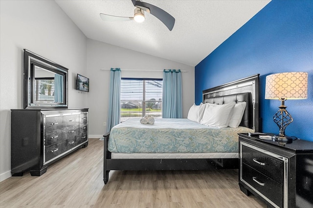 bedroom featuring multiple windows, light hardwood / wood-style floors, vaulted ceiling, and ceiling fan