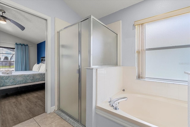 bathroom with ceiling fan, separate shower and tub, tile patterned flooring, and vaulted ceiling