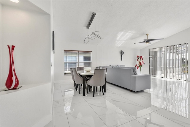 dining space featuring a textured ceiling, vaulted ceiling, and ceiling fan