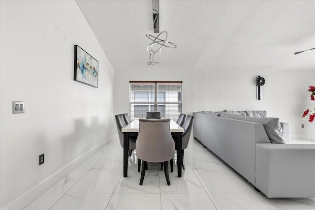 dining room featuring a textured ceiling and lofted ceiling