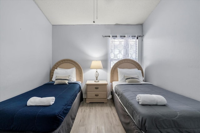 bedroom featuring light hardwood / wood-style floors and a textured ceiling