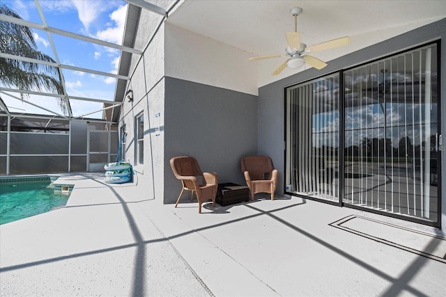 view of patio with ceiling fan and glass enclosure