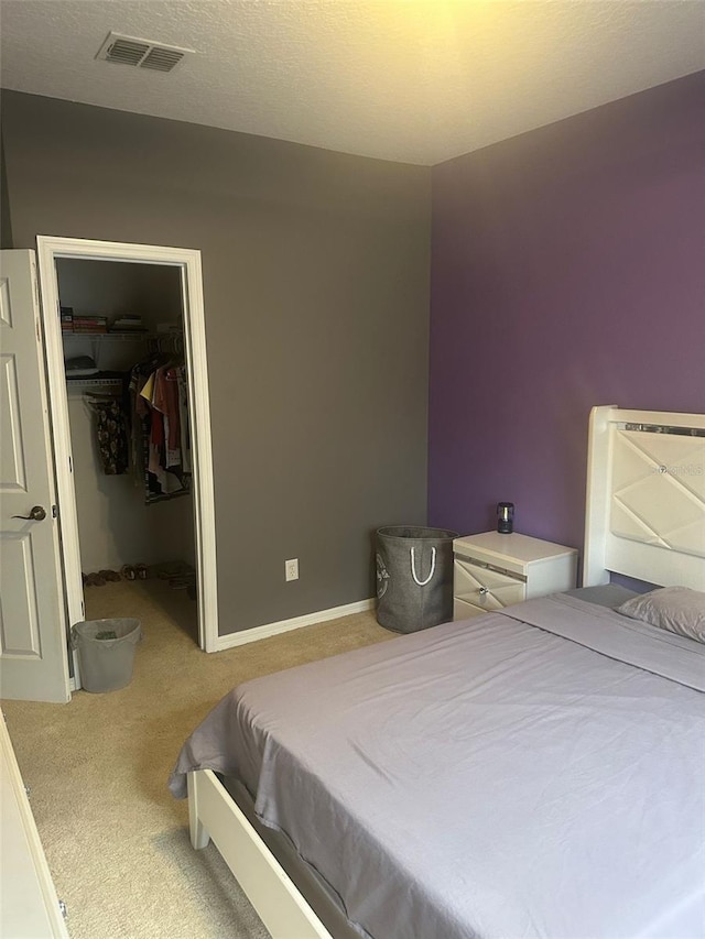 bedroom featuring a closet, carpet, and a walk in closet