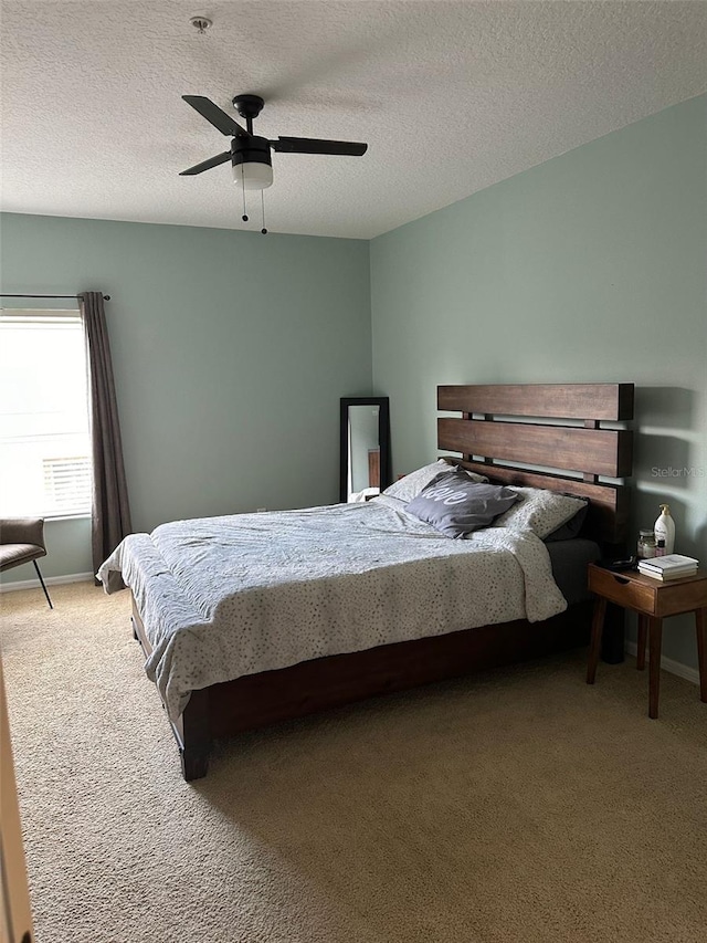 carpeted bedroom with a textured ceiling and ceiling fan