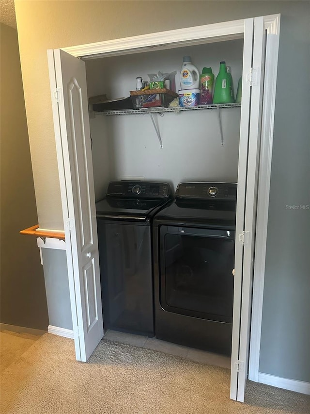 laundry area with washer and dryer and light colored carpet