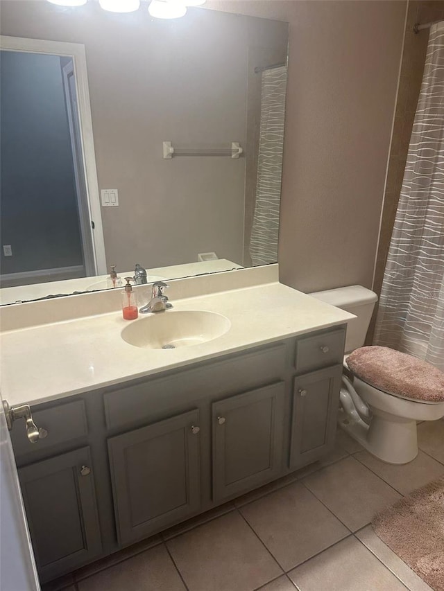 bathroom with vanity, tile patterned flooring, toilet, and curtained shower