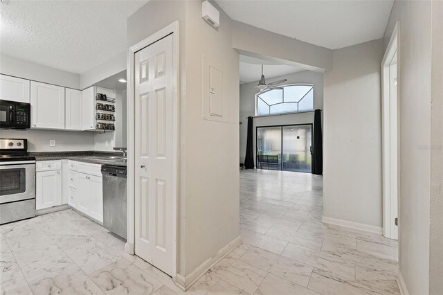 kitchen featuring ceiling fan, white cabinets, a textured ceiling, and appliances with stainless steel finishes