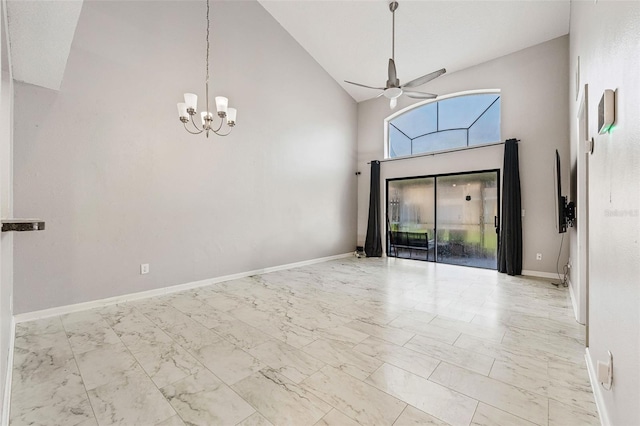 empty room featuring ceiling fan with notable chandelier and high vaulted ceiling