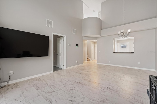 unfurnished living room featuring a notable chandelier and a high ceiling