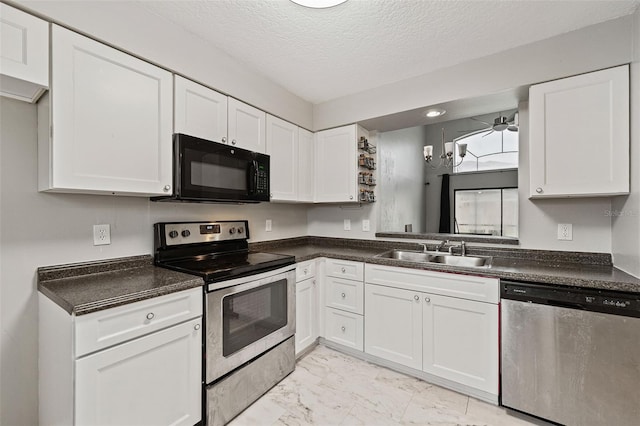 kitchen with a textured ceiling, stainless steel appliances, sink, and white cabinetry