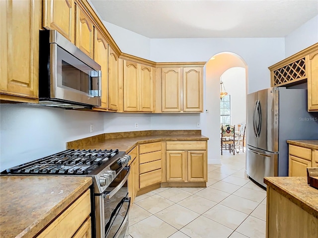 kitchen featuring light brown cabinets, light tile patterned flooring, and stainless steel appliances