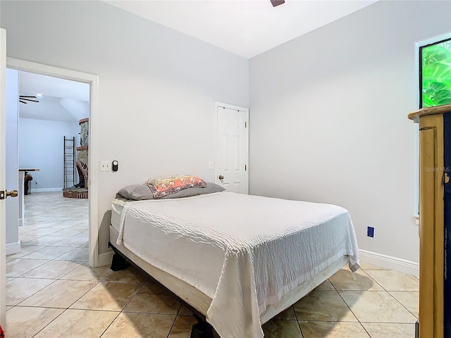 bedroom featuring ceiling fan, vaulted ceiling, and light tile patterned floors