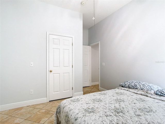 bedroom with a high ceiling and light tile patterned floors