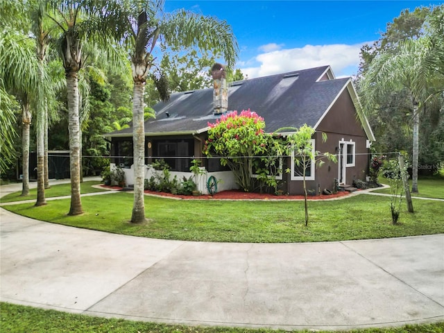 view of front of house featuring a sunroom and a front lawn