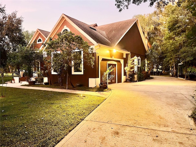 property exterior at dusk with a lawn