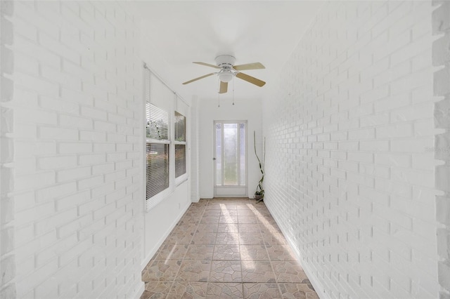 interior space featuring brick wall and ceiling fan