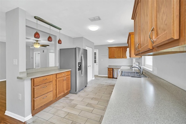 kitchen with pendant lighting, ceiling fan, stainless steel fridge with ice dispenser, and sink