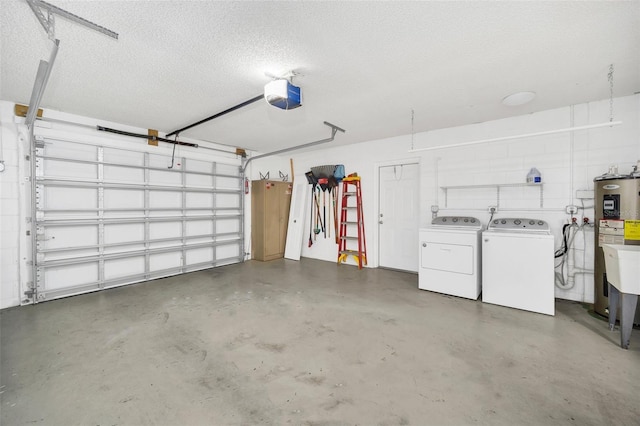 garage with a garage door opener, washing machine and dryer, and water heater