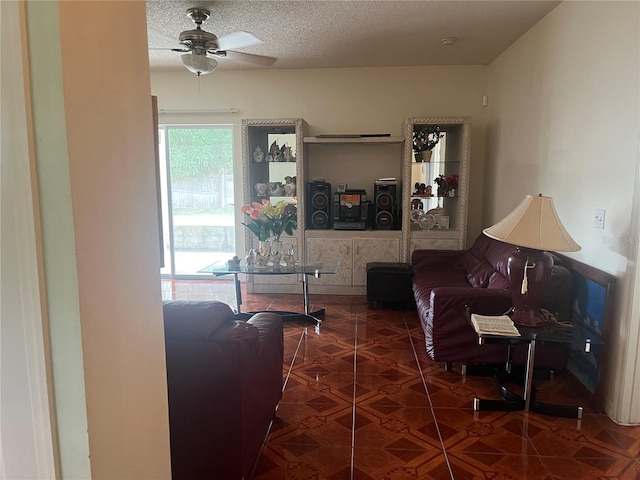 tiled living room featuring ceiling fan and a textured ceiling