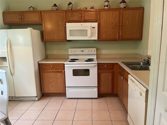 kitchen featuring light tile patterned floors, sink, and white appliances