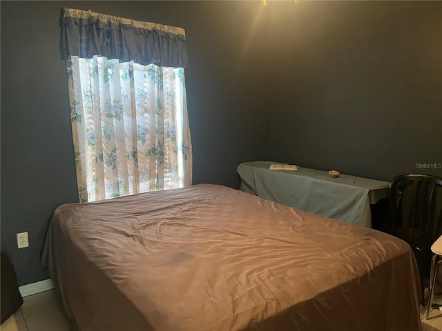 bedroom with light tile patterned floors and multiple windows