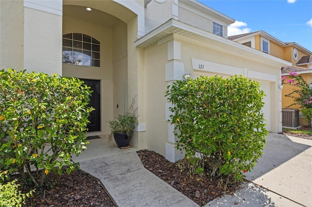 doorway to property featuring cooling unit and a garage